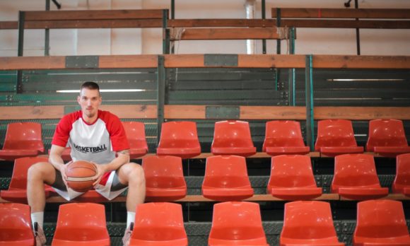 Basketball player sitting with ball